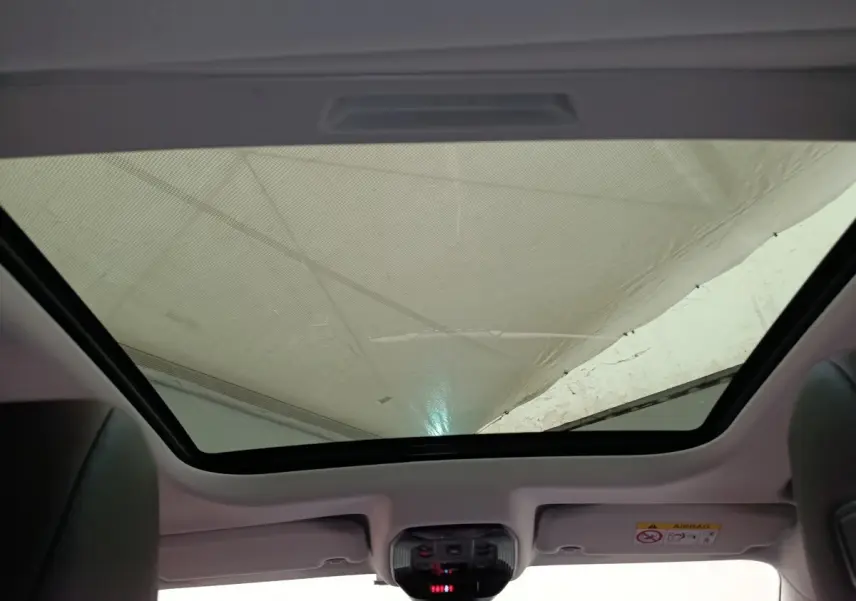 Toit panoramique vu de l'intérieur arrière du DS4 E-TENSE 225 gris clair, mettant en valeur la large surface vitrée.