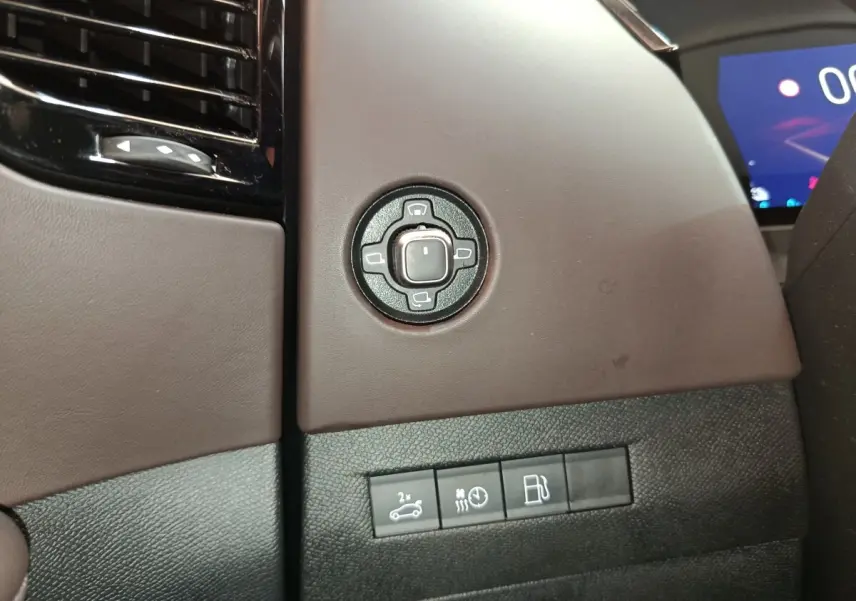 Détail du panneau de commandes côté gauche intérieur du DS4 E-TENSE 225 gris clair avec réglages rétroviseurs et boutons fonctionnels.