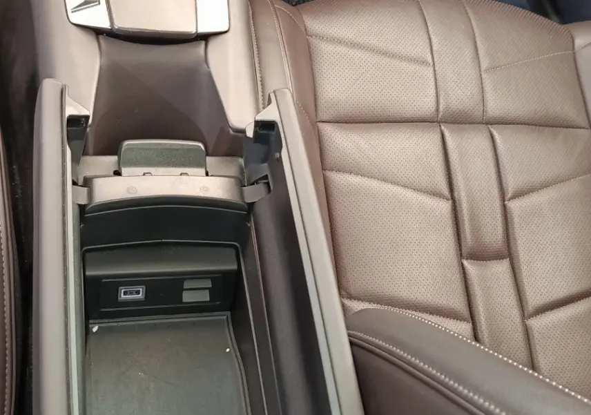 Vue plongeante sur la console centrale ouverte et siège en cuir marron du DS4 E-TENSE 225 gris clair.