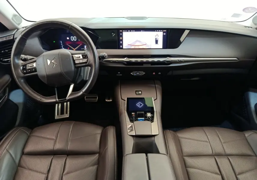 Vue intérieure avant du DS4 E-TENSE 225 gris, montrant le volant cuir, tableau de bord numérique et console centrale moderne.
