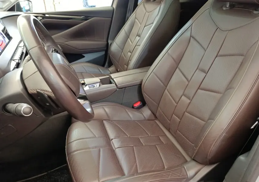 Intérieur avant droit du DS4 E-TENSE 225 LA PREMIERE 2021 avec sièges cuir marron et volant cuir réglable.