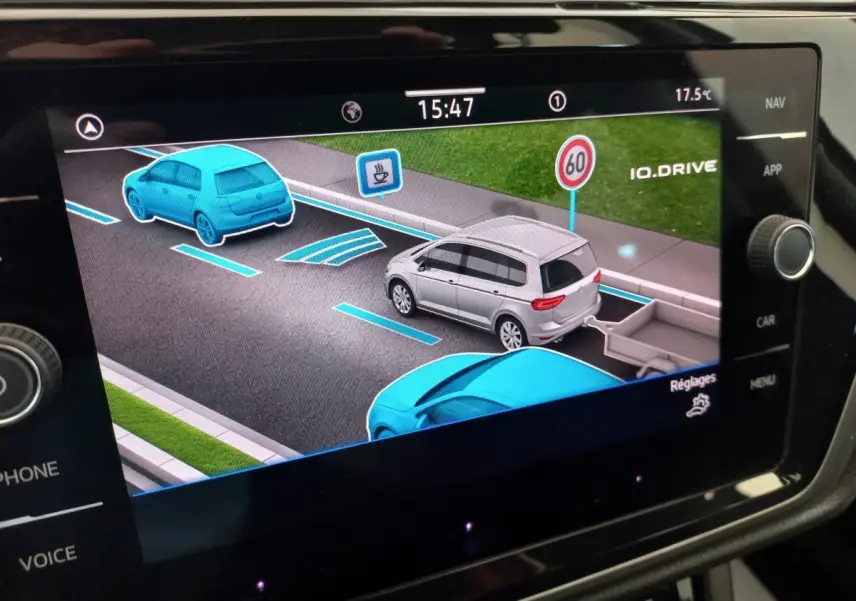 Affichage tactile du système de navigation montrant une Volkswagen Touran grise vue de trois quarts arrière avec remorque virtuelle.