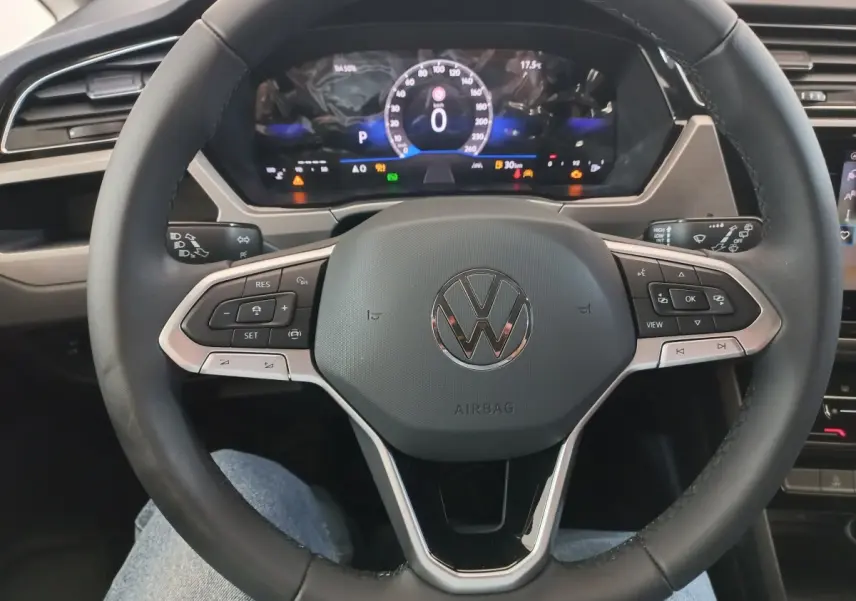 Vue rapprochée du volant noir multifonctions et du combiné d'instruments digital du Volkswagen Touran 2024.