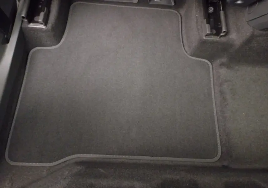 Tapis de sol noir côté conducteur du Volkswagen Touran 2024, vue rapprochée de l'intérieur au sol.