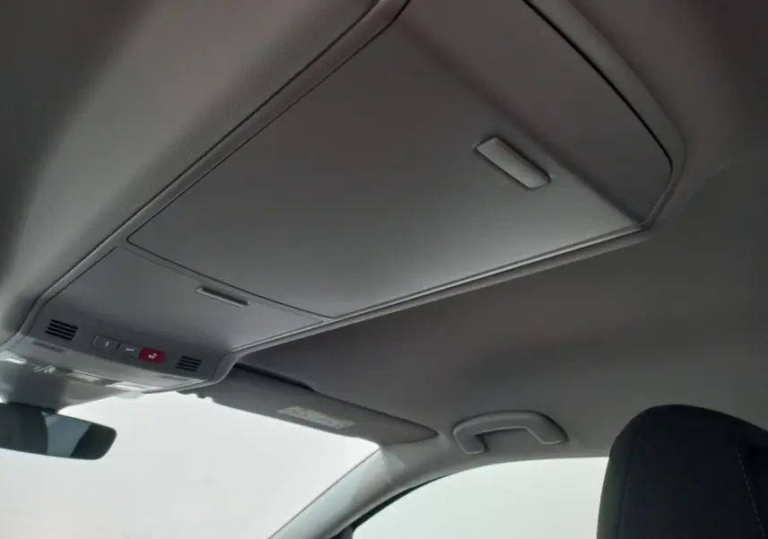 Plafonnier intérieur avec commandes d'urgence et pare-soleil côté conducteur du Volkswagen Touran noir 2024.