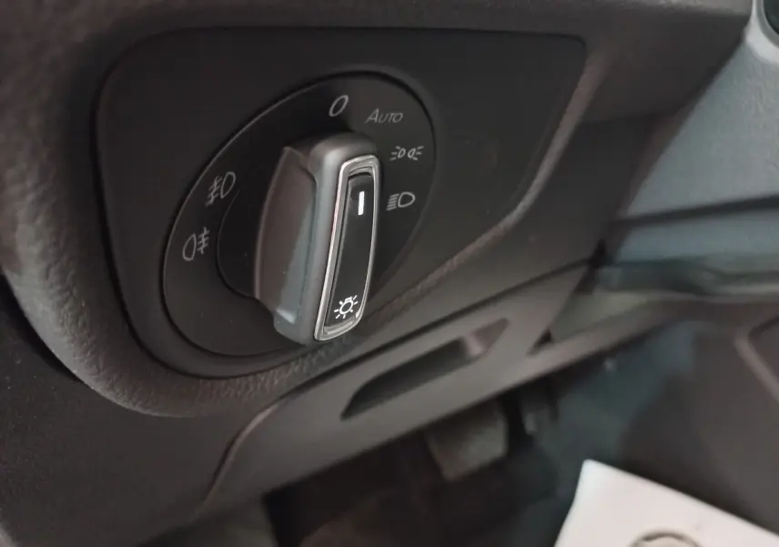 Gros plan sur la commande des phares noirs du Volkswagen Touran 2024, avec réglages d’éclairage visibles.