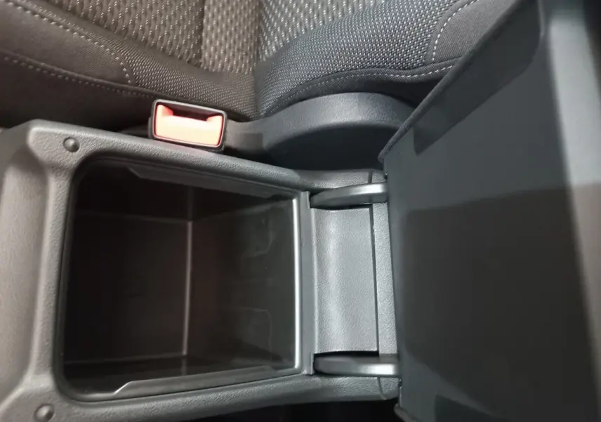 Vue rapprochée du rangement central ouvert, intérieur noir avec tissu et plastique, Volkswagen Touran 2024.