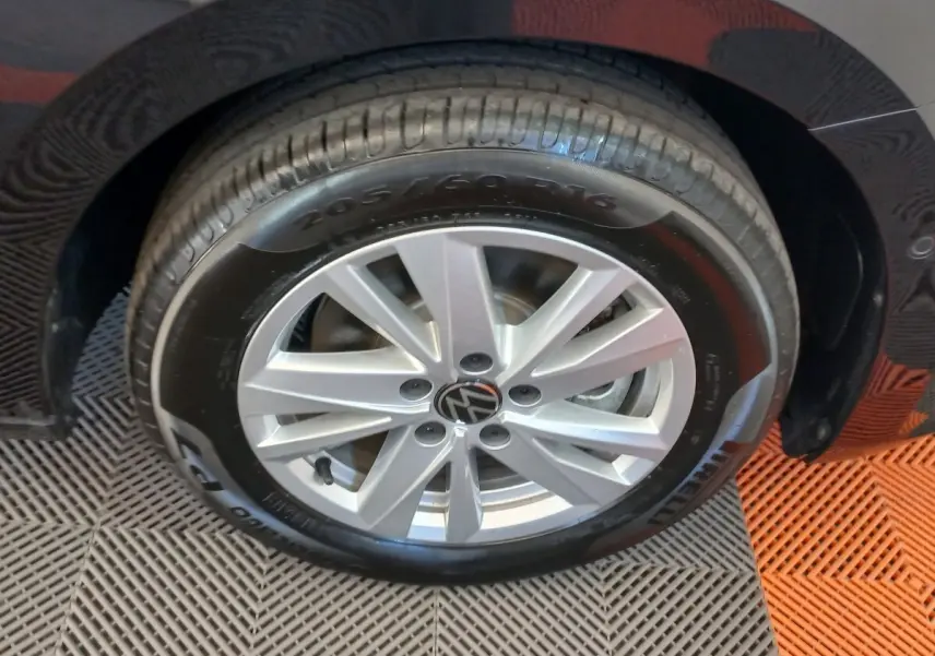 Gros plan sur la roue avant droite noire d’un Volkswagen Touran 2024 avec jante argentée et pneu Pirelli.