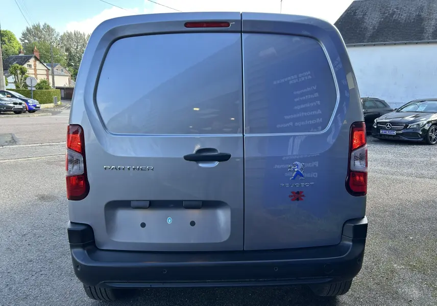 Vue arrière d'un Peugeot Partner gris Artense avec logo Dangel 4x4 et portes battantes fermées.