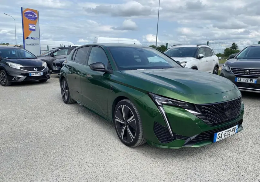 Peugeot 308 Vert Olivine vue 3/4 avant droit, avec calandre noire et feux LED en forme de griffes.