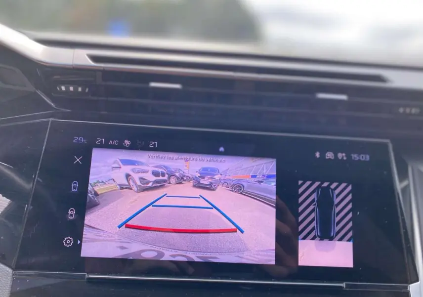 Écran central tactile de la Peugeot 308 2023 montrant la caméra de recul avec vue arrière et guidage de stationnement.