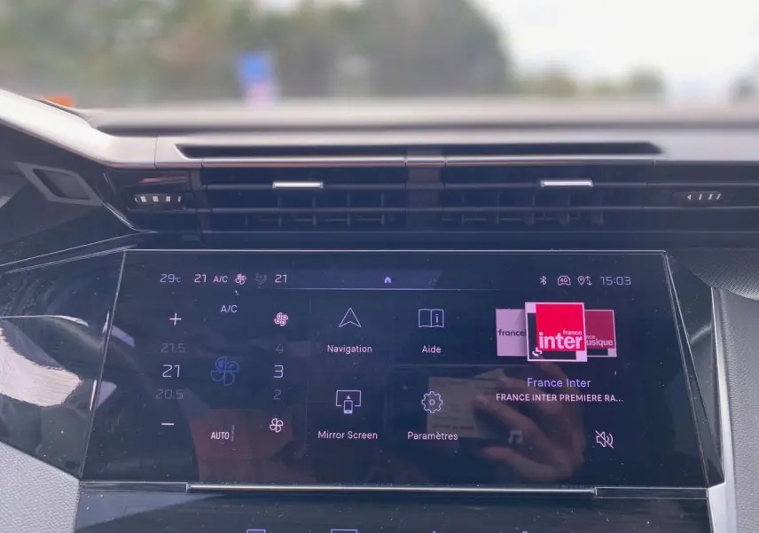 Écran tactile central du Peugeot 308 2023 affichant la navigation et la radio France Inter, vue de face intérieure.