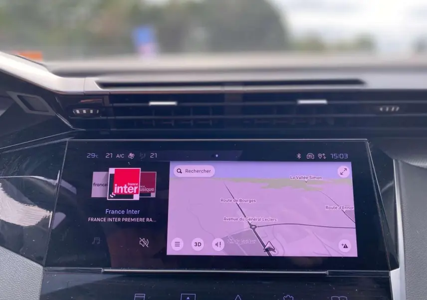 Écran tactile central de la Peugeot 308 2023 affichant navigation et radio France Inter, vue intérieure du tableau de bord.