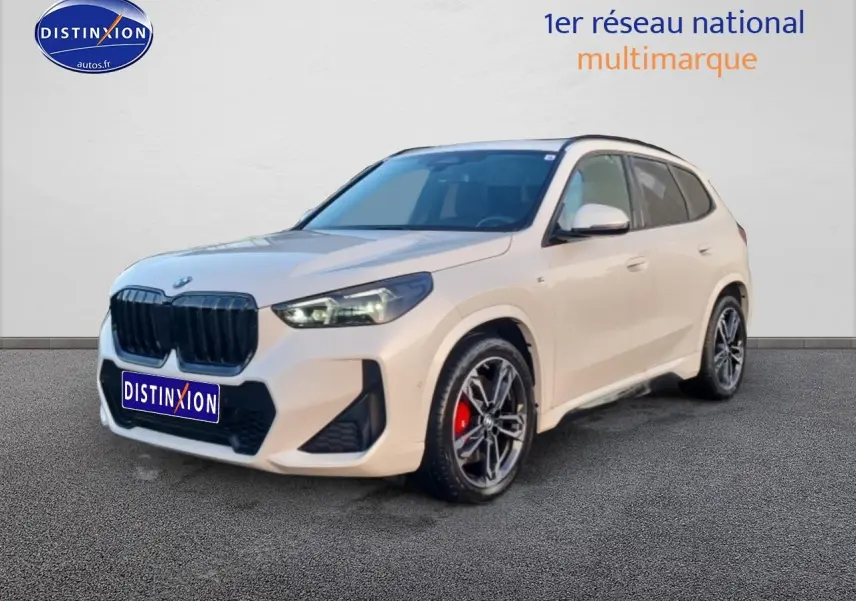 BMW X1 blanc minéral en 3/4 avant droit avec jantes alliage bicolores et étriers de frein rouges visibles