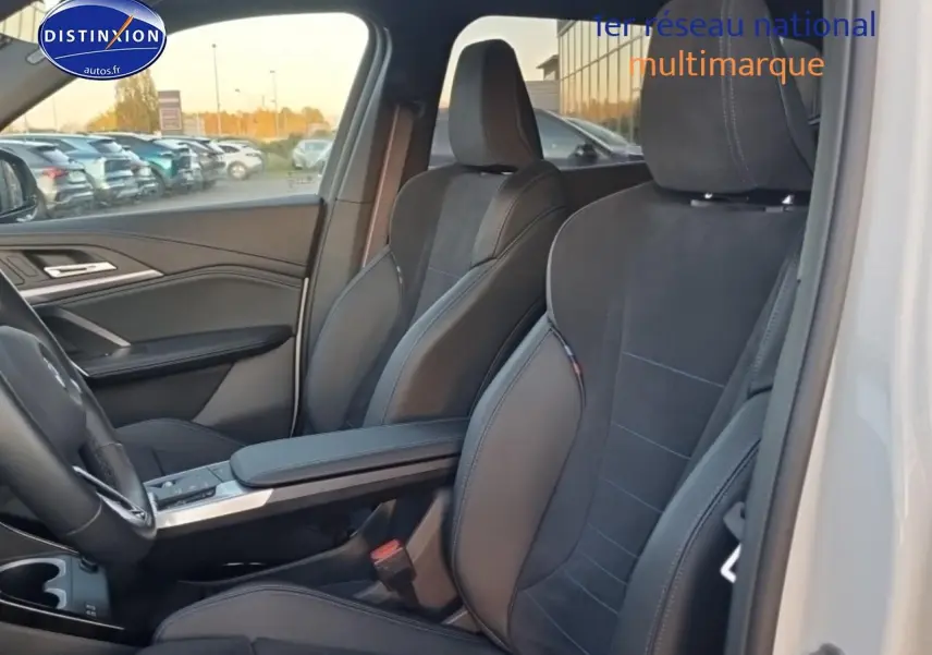 Vue intérieure côté conducteur du BMW X1 blanc mineral 2025, sièges sport noirs et volant cuir M visible.