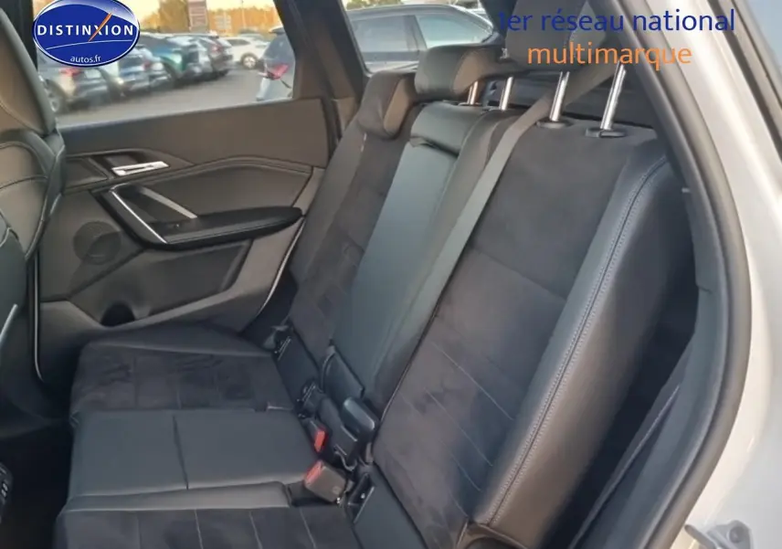 Vue intérieure côté gauche des sièges arrière noirs en cuir et alcantara du BMW X1 blanc mineral 2025.