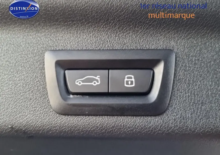 Gros plan sur les boutons d'ouverture du hayon et de verrouillage intérieur du BMW X1 blanc mineral 2025.