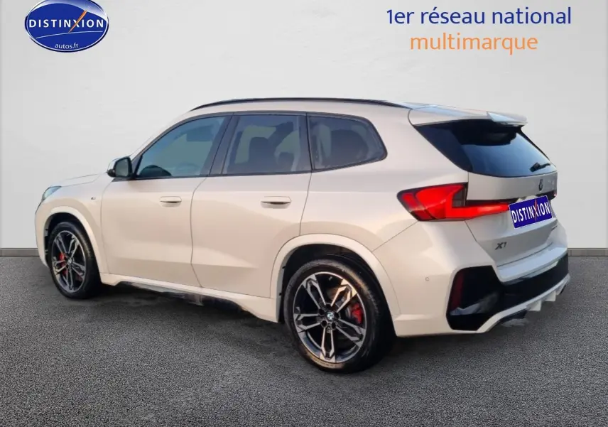 BMW X1 blanc minéral vue 3/4 arrière droit avec jantes alliage bicolores et détails M Sport pro.
