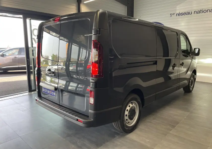 Vue 3/4 arrière droite du Renault Trafic Fourgon gris Comète, avec portes arrière fermées et jantes tôlées 16 pouces.