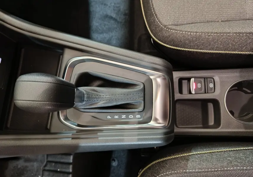 Gros plan sur la console centrale du Renault Captur blanc 2025, montrant le levier de boîte automatique et frein à main électrique.