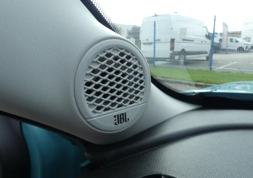 Gros plan sur haut-parleur JBL intérieur côté gauche du tableau de bord d’un Jeep Avenger bleu métallisé 2024.
