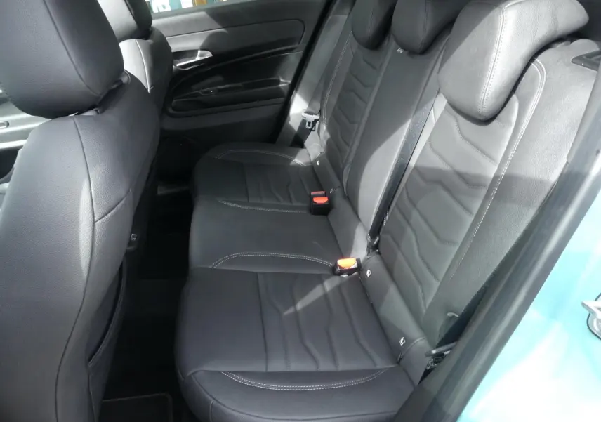 Vue côté droit des sièges arrière en cuir noir du Jeep Avenger 2024 avec portières bleu métallisé ouvertes.