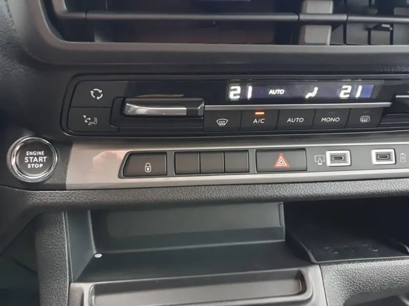 Gros plan sur la console centrale du Citroën Jumpy gris Titane, avec commandes climatisation digitale et bouton start/stop.