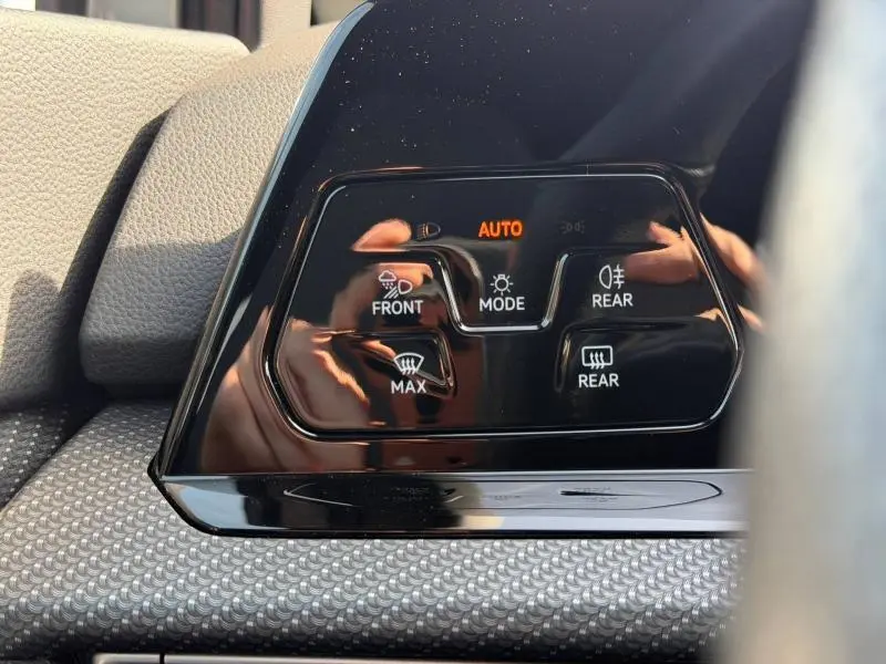 Gros plan sur les commandes d’éclairage automatiques du tableau de bord d’une Volkswagen Golf 2024 finition R-Line.