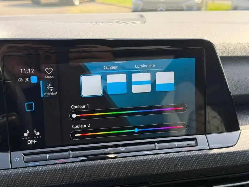 Écran tactile central de la Volkswagen Golf 2024 affichant les réglages de couleur et luminosité de l'ambiance intérieure.