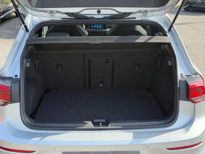 Coffre ouvert vu de l'arrière d'une Volkswagen Golf 1.5 eTSI R-Line 2024 en Reflet d'Argent métallisée, montrant l'espace de chargement.