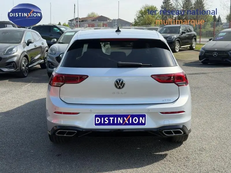 Vue arrière d'une Volkswagen Golf 1.5 eTSI R-Line 2024 en Reflet d'Argent métallisé avec double sortie d'échappement carrée.