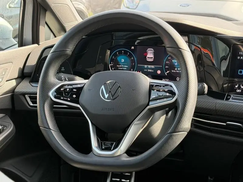 Vue rapprochée du volant multifonction et du tableau de bord numérique d'une Volkswagen Golf 2024 finition R-Line.