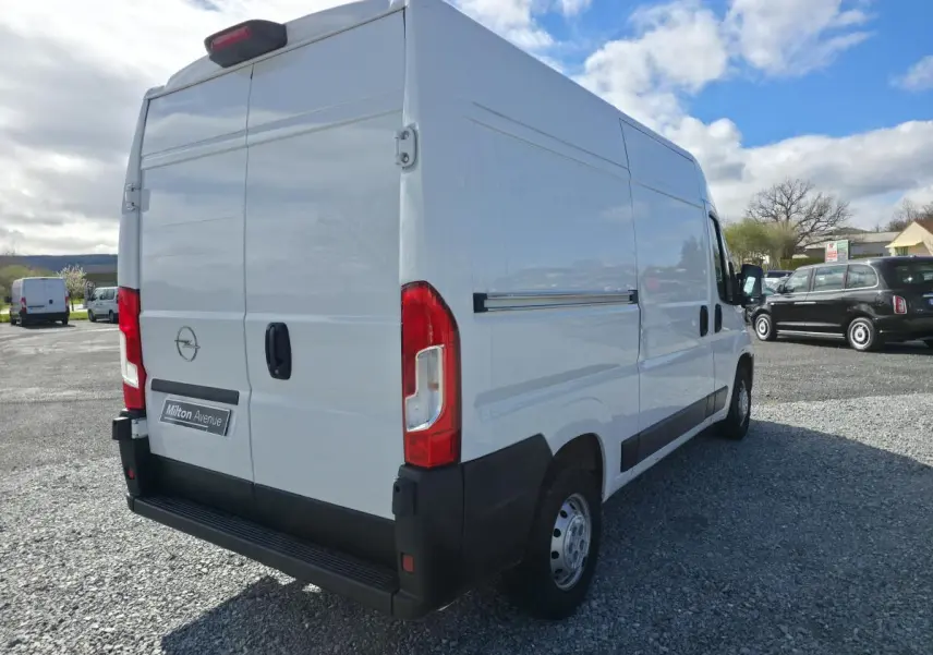 Vue 3/4 arrière droite d’un Opel Movano Fourgon blanc avec portes battantes arrière et porte latérale coulissante.