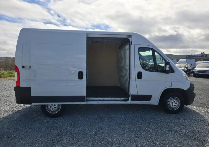 Opel Movano Fourgon blanc vue de profil droit avec porte latérale coulissante ouverte montrant l’espace de chargement.