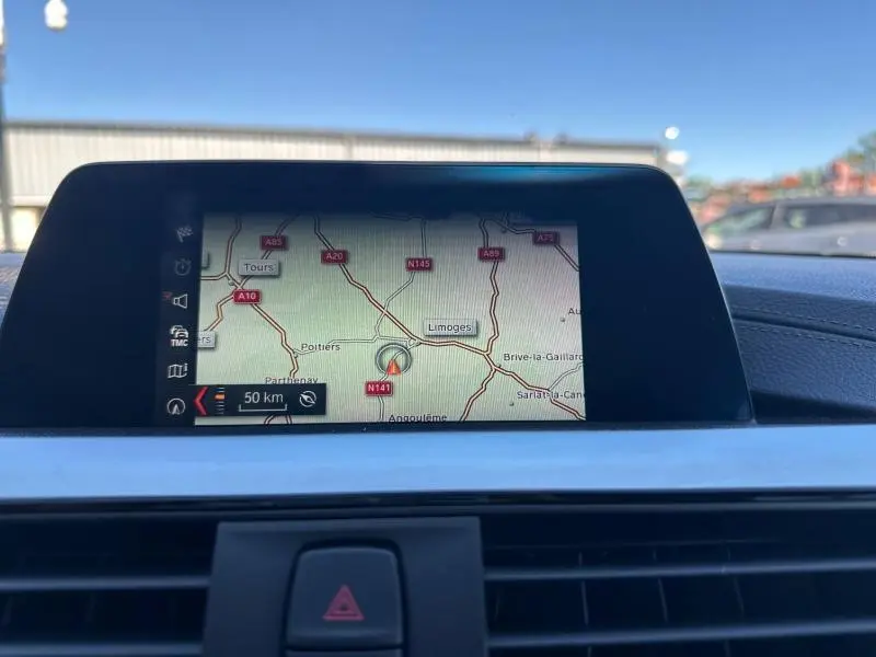 Écran GPS couleur intégré au tableau de bord d'une BMW Série 4 Gran Coupe F36 noire, vue frontale intérieure.