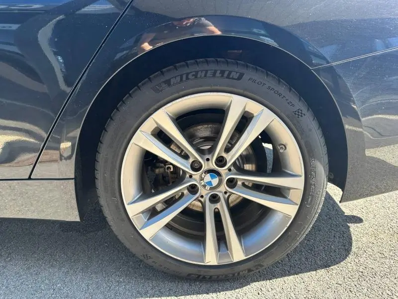 Gros plan sur la roue arrière droite noire d’une BMW Série 4 Gran Coupe F36 avec jante alliage et pneu Michelin Pilot Sport.