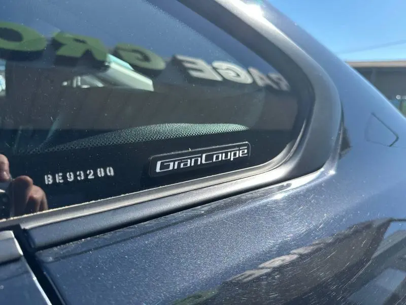 Gros plan sur l'arrière droit noir d'une BMW Série 4 Gran Coupe avec l'insigne "Gran Coupe" visible sur la vitre.