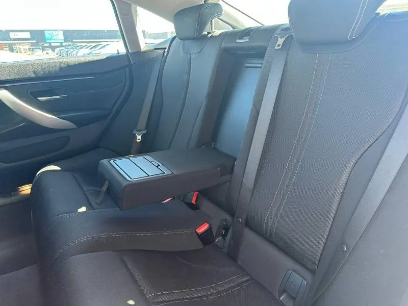 Vue intérieure arrière de la BMW Série 4 Gran Coupe F36 noire, montrant la banquette avec accoudoir central déplié.