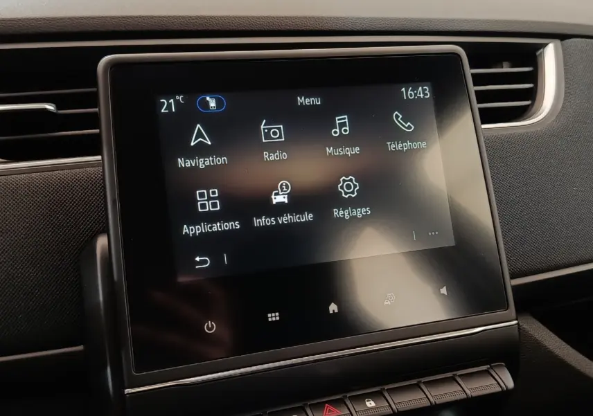 Écran tactile central affichant le menu multimédia dans l’habitacle sombre d’une Renault ZOE blanche 2021.