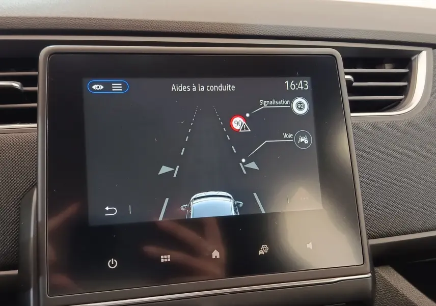 Écran tactile central de la Renault ZOE 2021 blanc affichant l'aide à la conduite avec détection de voie et signalisation.