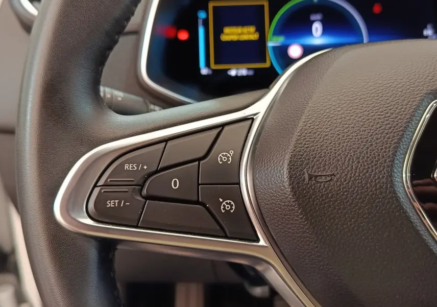 Gros plan sur le volant cuir synthétique noir de la Renault ZOE 2021 avec commandes multifonctions côté gauche.