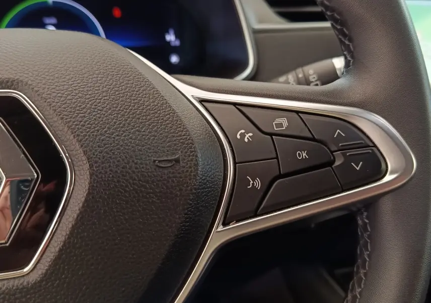 Gros plan sur le volant en cuir synthétique noir de la Renault ZOE 2021, avec commandes multifonctions à droite.