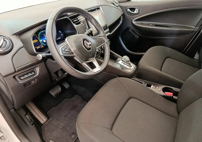 Vue intérieure côté conducteur de la Renault ZOE 2021, volant multifonctions cuir synthétique et écran tactile central visible.