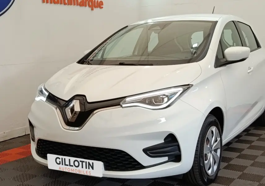 Vue 3/4 avant d'une Renault ZOE Business Rev R110 blanche, avec phares LED et calandre noire brillante.