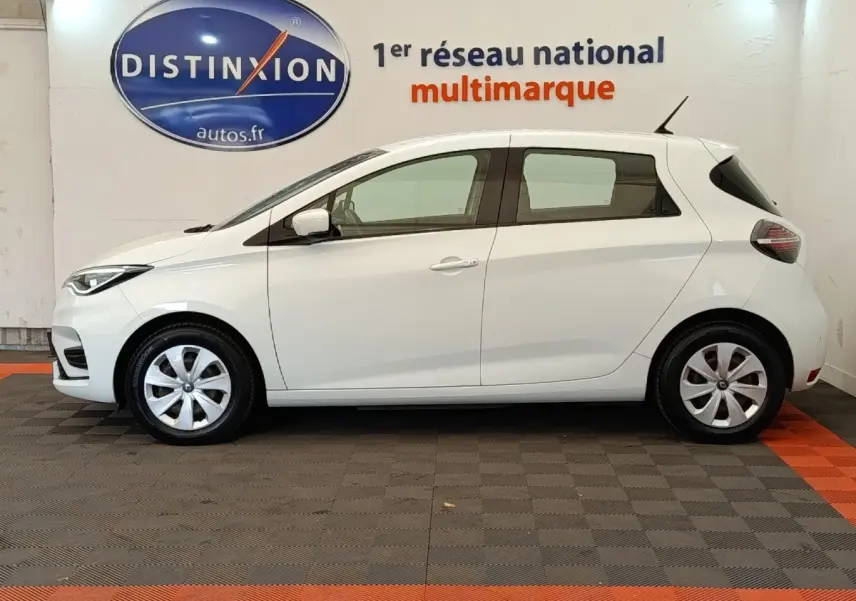 Profil côté gauche d'une Renault ZOE blanche 2021 Business Rev R110, avec jantes alliage et feux arrière LED visibles.