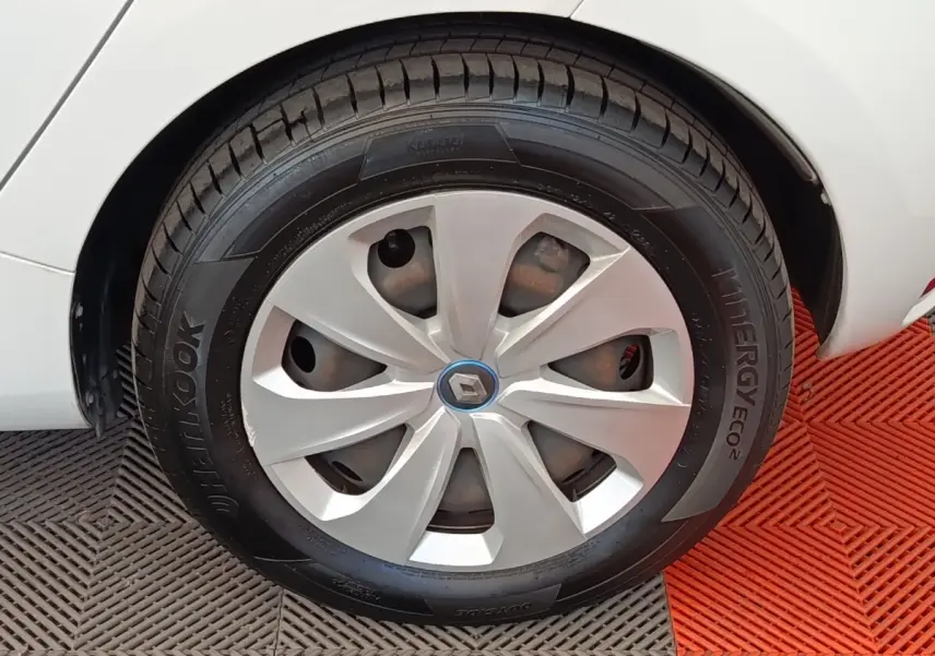 Gros plan sur la roue arrière droite blanche d'une Renault ZOE 2021 avec jante en alliage et logo Renault central.