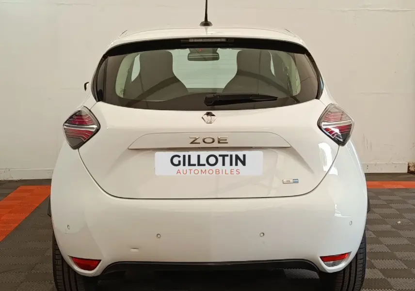 Vue arrière de la Renault ZOE Business blanche de 2021, avec feux arrière distinctifs et logo ZOE visible.