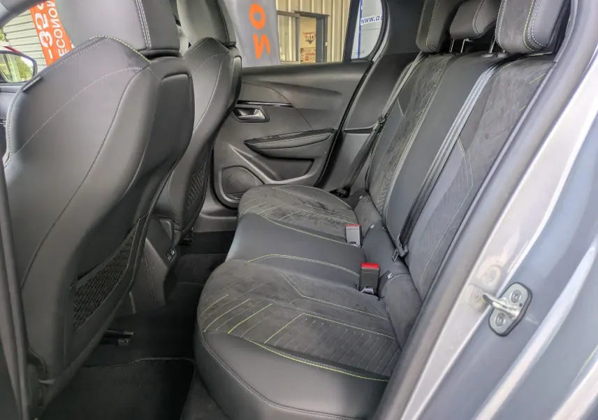 Vue intérieure côté droit des sièges arrière en Alcantara noir avec surpiqûres vertes du Peugeot 208 gris Artense 2025.