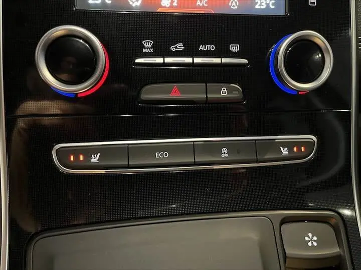 Gros plan sur la console centrale du Renault Scenic IV noir étoile métal, avec commandes climatisation et sièges chauffants activés.