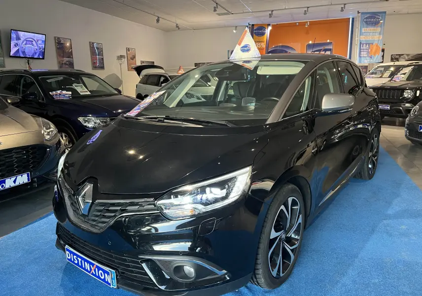 Renault Scenic IV noir étoile métal avec toit gris, vue 3/4 avant droit en showroom lumineux.